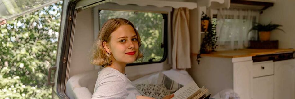 Young lady relaxing and reading in an RV